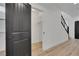 Hallway with a dark door, wooden floors, and a view of the staircase at 8043 Tank Loop St, Las Vegas, NV 89166