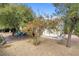 Large backyard with mature trees offering shade and privacy, plus a paved patio area at 8217 Ashkum Ave, Las Vegas, NV 89149