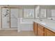 Bathroom featuring a soaking tub, glass shower, and double vanity at 8217 Ashkum Ave, Las Vegas, NV 89149