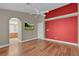 Bedroom featuring hardwood floors, with an en suite bathroom view and a red accent wall at 8217 Ashkum Ave, Las Vegas, NV 89149
