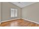 Bright bedroom featuring laminated wood floors, white trim, ceiling fan, and a window with wood blinds at 8217 Ashkum Ave, Las Vegas, NV 89149