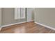 Cozy bedroom featuring laminated wood floors, window with wooden blinds and white trim at 8217 Ashkum Ave, Las Vegas, NV 89149