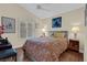 Well-lit bedroom featuring hardwood floors, neutral paint, a patterned bedspread, and simple decor at 8217 Ashkum Ave, Las Vegas, NV 89149