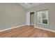 Cozy bedroom featuring hardwood floors, neutral walls, and a large window with plantation shutters at 8217 Ashkum Ave, Las Vegas, NV 89149