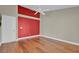 Bedroom featuring hardwood floors, a ceiling fan, and a bold red accent wall at 8217 Ashkum Ave, Las Vegas, NV 89149
