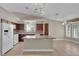 Bright kitchen area featuring an island, dark wood cabinets, and abundant natural light from nearby windows at 8217 Ashkum Ave, Las Vegas, NV 89149