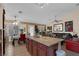 Open concept kitchen and dining area with dark cabinets, granite counters and ample seating at 8217 Ashkum Ave, Las Vegas, NV 89149