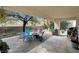 Relaxing covered patio features colorful seating, mature trees and desert landscaping at 8217 Ashkum Ave, Las Vegas, NV 89149