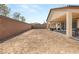 The backyard featuring ample space, a covered patio, and a privacy wall at 8575 Nicholas James Ave, Las Vegas, NV 89143