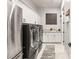 A well-equipped laundry room with washer, dryer, sink, and ample cabinet space for storage at 8575 Nicholas James Ave, Las Vegas, NV 89143