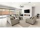 Spacious living room featuring a modern fireplace, large TV, and comfortable seating with backyard access at 8575 Nicholas James Ave, Las Vegas, NV 89143