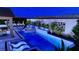 Night aerial view of a backyard oasis featuring a pool, hot tub, and lush landscaping with modern design at 8575 Nicholas James Ave, Las Vegas, NV 89143