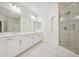 Elegant bathroom with a double vanity, large mirror, and glass-enclosed shower at 8591 Cloudy Dawn Way, Las Vegas, NV 89113