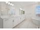 Bathroom featuring double vanity, soaking tub and a glass shower at 8591 Cloudy Dawn Way, Las Vegas, NV 89113