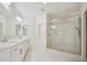 Modern bathroom featuring dual sinks, glass shower, and sleek white marble-style tile at 8591 Cloudy Dawn Way, Las Vegas, NV 89113