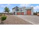Contemporary gray home featuring a three-car garage, modern architecture, and desert landscaping at 8591 Cloudy Dawn Way, Las Vegas, NV 89113