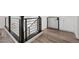 Modern hallway with wood floors, sleek metal railing, and a secure pet gate at 8591 Cloudy Dawn Way, Las Vegas, NV 89113