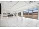 Spacious living room with a modern kitchen, large windows, and backyard access at 8591 Cloudy Dawn Way, Las Vegas, NV 89113