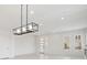 Bright living room featuring a modern chandelier, white walls, and tile flooring at 8591 Cloudy Dawn Way, Las Vegas, NV 89113