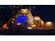 Outdoor oasis featuring a modern pool, spa, fire pit, and covered patio with ambient lighting at 9117 Hickam Ave, Las Vegas, NV 89129