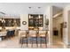 An elegant bar featuring a stacked stone base, seating for three, and a cabinet stocked with glassware and spirits at 9117 Hickam Ave, Las Vegas, NV 89129