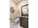 Half bathroom featuring stone countertop, wood cabinetry and tiled floors at 9117 Hickam Ave, Las Vegas, NV 89129