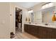 Bathroom featuring double sinks, granite counters, and walk-in closet at 9117 Hickam Ave, Las Vegas, NV 89129