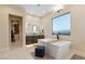 Serene bathroom featuring a freestanding tub, dual vanities, and a walk-in closet, perfect for relaxation and organization at 9117 Hickam Ave, Las Vegas, NV 89129