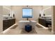 Elegant bathroom with dual sinks, a soaking tub beneath a window, and modern fixtures, offering a spa-like experience at 9117 Hickam Ave, Las Vegas, NV 89129