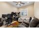 Comfortable bedroom with a leather recliner, ceiling fan, and ample desk space illuminated by natural light at 9117 Hickam Ave, Las Vegas, NV 89129