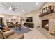 Cozy living room featuring a stone fireplace, comfortable seating, and a modern ceiling fan at 9117 Hickam Ave, Las Vegas, NV 89129