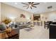Open-concept living room with tile floors, ceiling fan, gray sofa and kitchen view at 9117 Hickam Ave, Las Vegas, NV 89129
