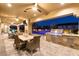 Outdoor kitchen and dining area overlooking the pool, complete with a built-in grill and comfortable seating at 9117 Hickam Ave, Las Vegas, NV 89129