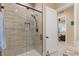 A sleek walk-in shower showcasing neutral tile, modern fixtures, and a convenient niche for bath products at 9117 Hickam Ave, Las Vegas, NV 89129