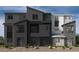 Modern three-story townhome with a geometric facade and neutral color palette, showcasing contemporary design at 9233 Soho Sky Ct, Las Vegas, NV 89148