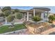 Well-manicured backyard with lush landscaping and covered patio at 10235 Tresor Ct, Las Vegas, NV 89135
