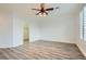 Spacious bedroom featuring wood-look flooring, ceiling fan, and natural light at 10235 Tresor Ct, Las Vegas, NV 89135