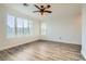 Bright bedroom featuring wood-look flooring, ceiling fan, and plantation shutters at 10235 Tresor Ct, Las Vegas, NV 89135