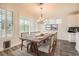 Dining room with a wooden table set for six, chandelier, and shuttered windows at 10235 Tresor Ct, Las Vegas, NV 89135