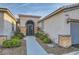 Close-up of the front entrance with an iron gate and desert landscaping at 10235 Tresor Ct, Las Vegas, NV 89135