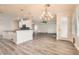 Open-concept living area with wood floors, stylish light fixture, and natural light at 10235 Tresor Ct, Las Vegas, NV 89135