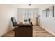 Home office with modern desk, wood floors, and natural light from the window at 10235 Tresor Ct, Las Vegas, NV 89135