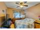 Comfortable bedroom with ceiling fan, window with floral curtains and bright natural light at 10450 Kepler Cascades St, Las Vegas, NV 89141