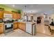 Open kitchen and living room view features tile floors, a ceiling fan, and plentiful wooden cabinetry at 10450 Kepler Cascades St, Las Vegas, NV 89141