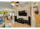 Open-concept living room featuring tile floors, staircase, and a wall-mounted television at 10450 Kepler Cascades St, Las Vegas, NV 89141