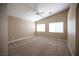 Spacious bedroom with neutral carpet, ceiling fan, and two windows offering abundant natural light at 10643 Petricola St # 103, Las Vegas, NV 89183