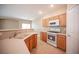 Bright kitchen featuring wooden cabinets, modern appliances, and a breakfast bar overlooking living space at 10643 Petricola St # 103, Las Vegas, NV 89183