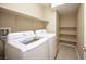 Well-equipped laundry room with washer, dryer, and shelving provides ample storage and convenience at 10643 Petricola St # 103, Las Vegas, NV 89183