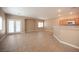 Spacious living room with tile flooring and natural light from the double french doors and the adjacent kitchen area at 10643 Petricola St # 103, Las Vegas, NV 89183
