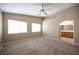 Large bedroom with neutral carpet and ceiling fan leads to an ensuite bathroom, providing comfort and privacy at 10643 Petricola St # 103, Las Vegas, NV 89183